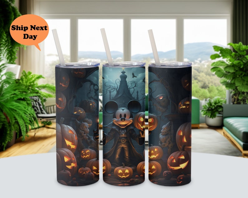 May include: Three stainless steel tumblers with a Halloween theme. The tumblers feature a Mickey Mouse character dressed as a vampire, surrounded by jack-o'-lanterns and other Halloween imagery.