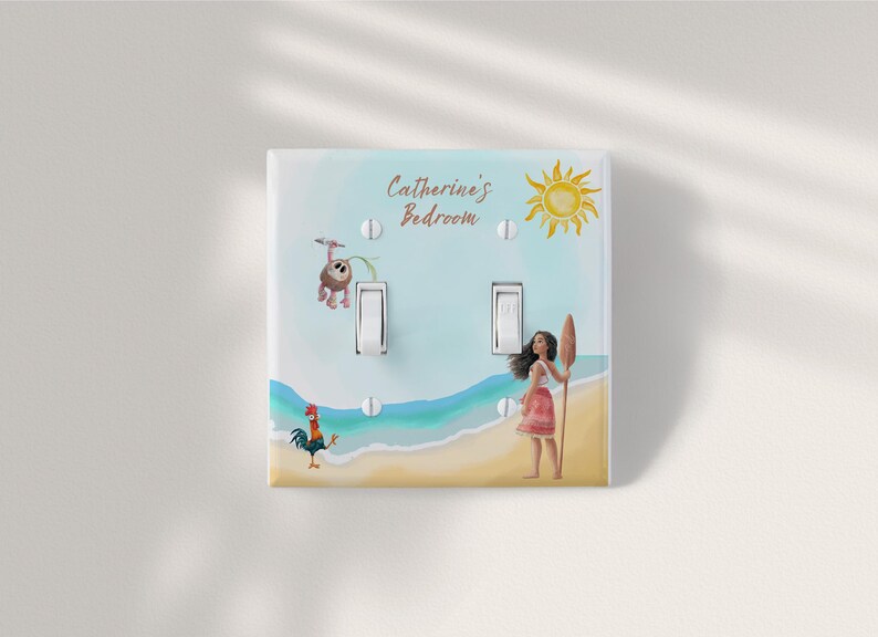 May include: A double light switch cover plate featuring a beach scene with a cartoon girl holding an oar, a rooster, and a small creature. The text "Catherine's Bedroom" is printed at the top, accompanied by a yellow sun illustration against a blue sky.