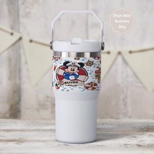 May include: White insulated tumbler with a handle and a decorative band featuring a cartoon Mickey Mouse in a sailor outfit. The band includes the name "Oliver" and nautical elements like life preservers and anchors.