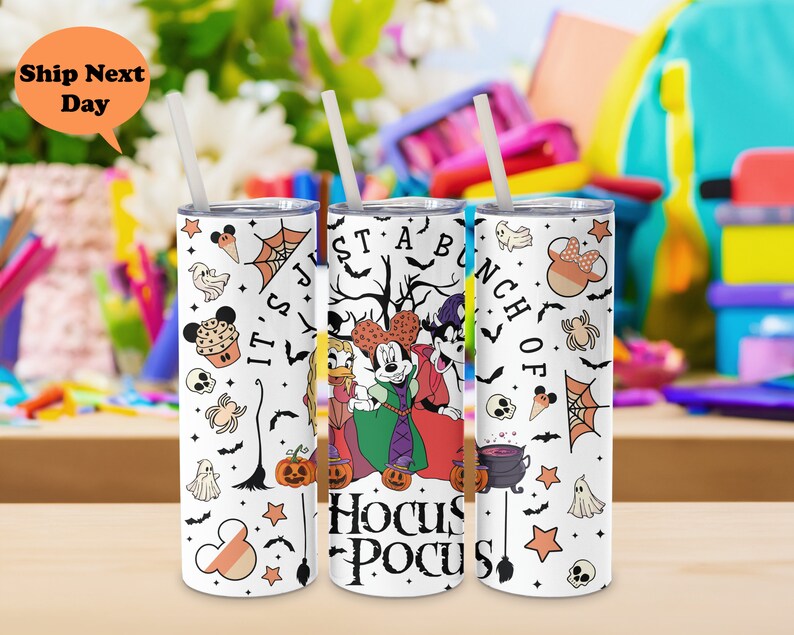 Puede incluir: Un vaso de acero inoxidable blanco con un tema de Halloween con Mickey Mouse, Minnie Mouse y Donald Duck vestidos con disfraces. El vaso tiene una variedad de gr&aacute;ficos de tem&aacute;tica de Halloween, incluyendo calabazas, murci&eacute;lagos, fantasmas y un caldero. El texto "It's Just A Bunch Of Hocus Pocus" est&aacute; impreso en el vaso.