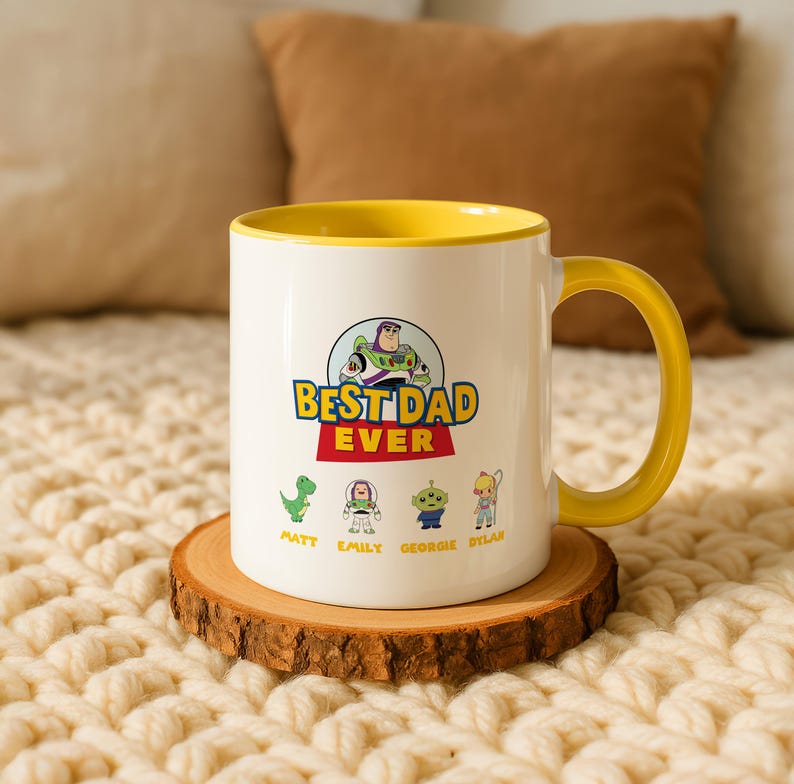 May include: A white ceramic mug with a yellow interior and handle. The front features a graphic of Buzz Lightyear above the text BEST DAD EVER, with smaller character illustrations of Rex, Buzz, an alien, and Bo Peep labeled Matt, Emily, Georgie, and Dylan.