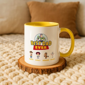 May include: A white ceramic mug with a yellow interior and handle, featuring a graphic of Buzz Lightyear and the text BEST DAD EVER. Below are four small cartoon characters with the names Matt, Emily, Georgie, and Dylan printed underneath.