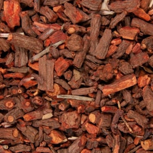 Könnte beinhalten: Nahaufnahme eines Haufens getrockneter roter und brauner Rindenstücke. Die Rinde ist in kleine, unregelmäßige Stücke zerbrochen.