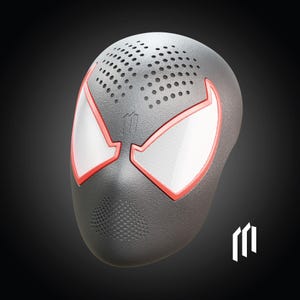 May include: A black mask with red trim and white eye shapes, resembling a superhero's mask. The mask has multiple small holes on the top and a speaker-like design at the bottom. A logo is visible on the bottom right.