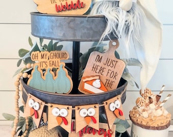 May include: A tiered tray decorated for fall with wooden signs that say "Gobble Til You Wobble", "Fall Y'all", "Oh My Gourd It's Fall", "I'm Just Here For The Pie", and "Flowers Are For Quitters". There is also a gnome, a turkey banner, a crocheted mushroom, and a mug that says "Thankful".