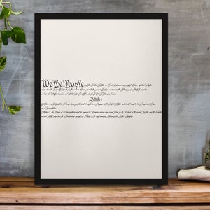 Puede incluir: Una impresi&oacute;n enmarcada en negro con el primer p&aacute;rrafo de la Constituci&oacute;n de los Estados Unidos, "We the People..." en una fuente cursiva sobre un fondo blanco.