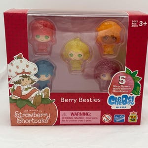 May include: A boxed set of five micro-figures from the Strawberry Shortcake "Berry Besties" collection. The figures are in a clear plastic case, with a red and white box featuring the Strawberry Shortcake logo and character illustrations.