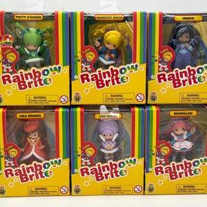 May include: Six Rainbow Brite dolls in their original boxes. Each doll is in a yellow box with a rainbow stripe design and the Rainbow Brite logo. The dolls are Patty O'Green, Rainbow Brite, Indigo, Lala Orange, Shy Violet, and Moonglow.