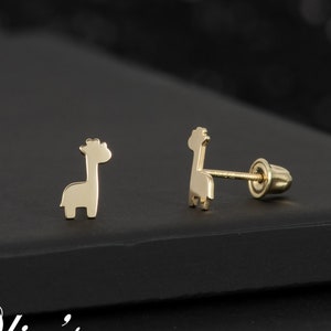 May include: A pair of gold-toned giraffe stud earrings. The earrings are small and delicate, and they would make a great gift for a child.