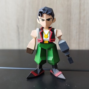 May include: A 3D-printed figurine of a male character with a geometric design. The figure wears a white shirt, green trousers, a black vest with red trim, and a gold necklace. One arm is a mechanical device. The figure has black hair and angular features.