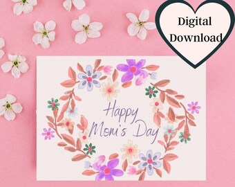 May include: A printable card with a floral wreath design and the text "Happy Mom's Day". The wreath is made up of pink, purple, and yellow flowers with green leaves.