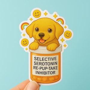 May include: A sticker featuring a cartoon golden retriever puppy peeking out of a pill bottle. The bottle reads "SELECTIVE SEROTONIN RE-PUP-TAKE INHIBITOR." Smiley faces and rainbows surround the puppy.