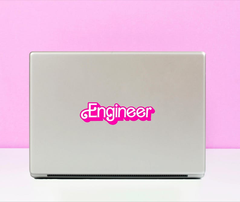 May include: A silver laptop computer with a pink sticker that says "Engineer" on the lid.