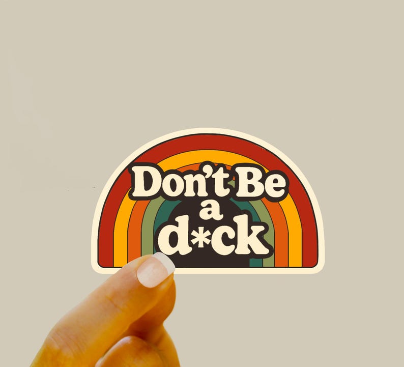 May include: A retro-style sticker with a rainbow design and the text "Don't Be a d*ck" in a bold, vintage font. The sticker has a cream-colored border and a neutral background.