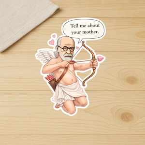 May include: A sticker featuring a cartoon of Sigmund Freud as Cupid, holding a bow and arrow with a heart-shaped tip. The speech bubble says, "Tell me about your mother." The image includes wings, a quiver of arrows, and pink hearts.