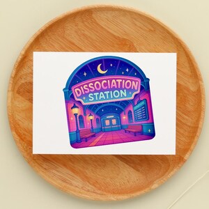 Puede incluir: Una colorida pegatina con una ilustraci&oacute;n estilizada de una estaci&oacute;n de metro. El texto "Dissociation Station" se muestra de forma destacada. El dise&ntilde;o incluye una luna creciente, estrellas y una vibrante paleta de colores rosa, morado y azul.