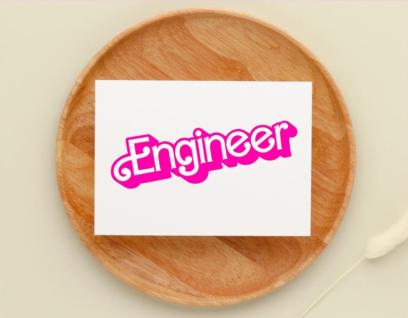 May include: A white card with the word "Engineer" written in pink, retro-style lettering. The card is sitting on a wooden tray.