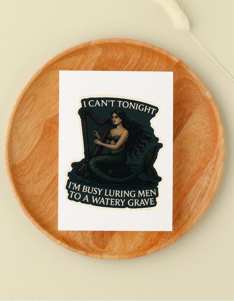 May include: A white sticker featuring a mermaid playing a harp. The mermaid has long dark hair and a green tail. Text on the sticker reads "I CAN'T TONIGHT" and "I'M BUSY LURING MEN TO A WATERY GRAVE."