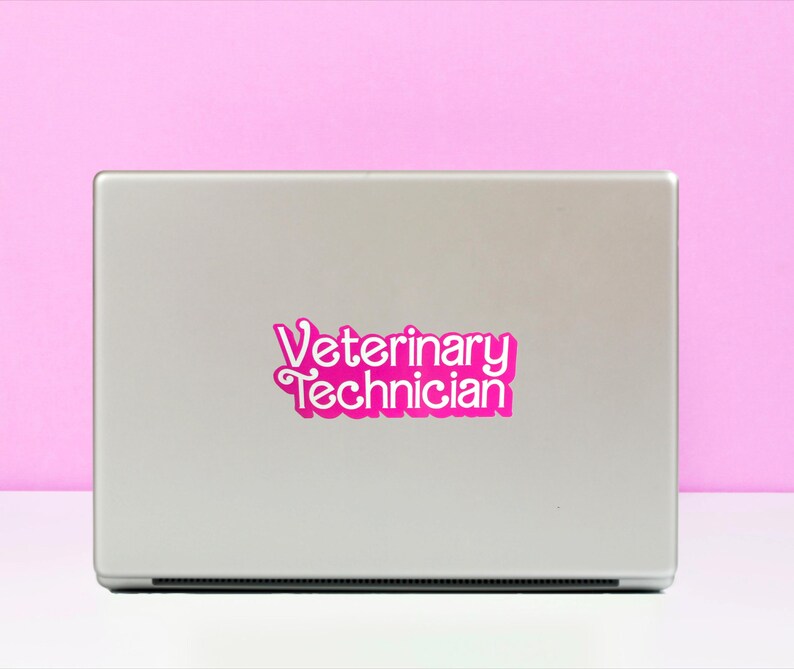Op de afbeelding: Een zilveren laptop met een roze sticker waarop "Veterinary Technician" staat.