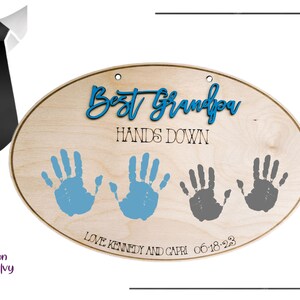 May include: Oval wooden sign with the text "Best Grandpa Hands Down" in black lettering.  The sign has three handprints, two in blue and one in gray, with the text "Love Kennedy and Capri 06-18-23" below the handprints.
