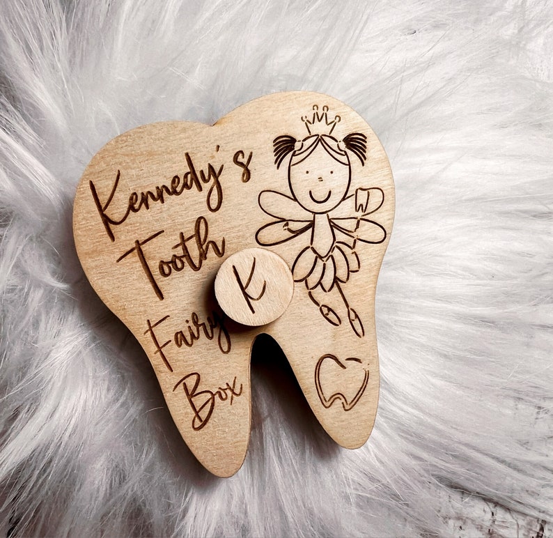 May include: Wooden tooth fairy box shaped like a tooth with a fairy illustration and the text "Kennedy's Tooth Fairy Box" and the letter "K" on the front.