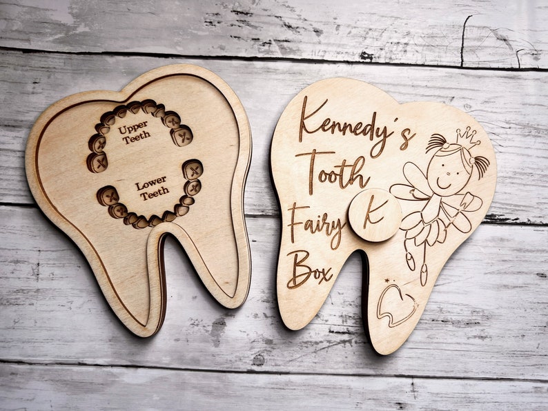 May include: A wooden tooth-shaped box with a slot for a tooth. The box is decorated with a fairy and the text "Kennedy's Tooth Fairy Box".