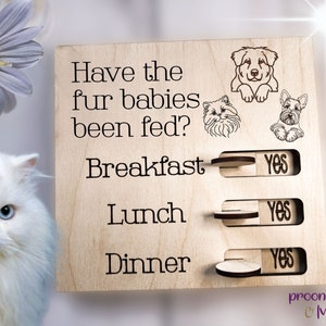 May include: A wooden sign with the text "Have the fur babies been fed?" and a sliding toggle switch for each meal: breakfast, lunch, and dinner. Each toggle switch has a "yes" option.