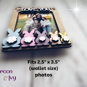 Peut inclure: Cadre photo en bois avec une photo de famille, orn&eacute; d'accents de lapins color&eacute;s. Le cadre est con&ccedil;u pour des photos de 6,35 cm x 8,89 cm et porte l'inscription "Love You" en haut. Le cadre pr&eacute;sente des queues de lapin bleues, roses, violettes, p&ecirc;che et jaunes.