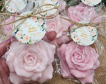 Puede incluir: Favores de jabón en forma de rosa rosa envueltos en bolsas de celofán transparentes con un lazo de cordel marrón y una etiqueta floral redonda que dice "Keishla & Donald's Baby Shower Thank You! 06.08.2024".