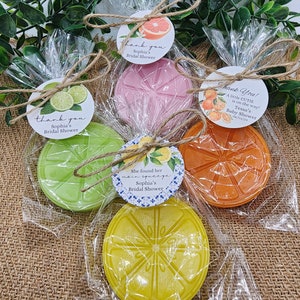 May include: Four favor boxes with citrus-themed soap and thank you tags. The tags say "Thank you, Sophia's Bridal Shower" and "Thank You! A little cutie is on the way! Tessa's Baby Shower 06/01/24".