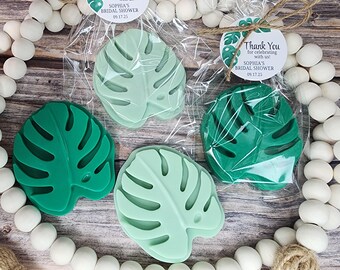 May include: Four leaf-shaped soaps in shades of green, packaged in clear cellophane. Each soap is a monstera leaf design. Two are unwrapped, and two are wrapped with a tag that reads "Thank You for celebrating with us! SOPHIA'S BRIDAL SHOWER 09.17.25".