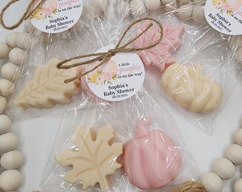 May include: Baby shower favors featuring leaf and pumpkin-shaped soaps in clear cellophane bags. Each bag is tied with twine and a circular tag that reads "A little pumpkin is on the way!" and "Sophia's Baby Shower 09.20.2025."