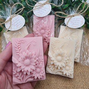 Puede incluir: Tres jabones peque&ntilde;os, rectangulares, con estampado floral envueltos en celof&aacute;n transparente con cuerda y una etiqueta redonda que dice "&iexcl;Gracias por celebrar a Sophia con amor!"