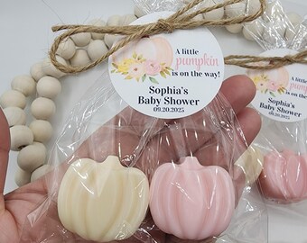 May include: Two pumpkin-shaped favors, one cream and one pink, in clear cellophane bags. Each favor is attached to a round tag with the text "A little pumpkin is on the way!" and "Sophia's Baby Shower 09.20.2025".