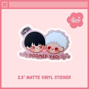 May include: A 2.5-inch matte vinyl sticker featuring two cartoon characters with black and white hair, red eyes, and the text "DOOMED YAOI". The sticker has a pink border and the text "EASY PEEL".
