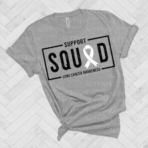 May include: Gray t-shirt with a black and white graphic that says "Support Squad" with a white ribbon and the text "Lung Cancer Awareness".