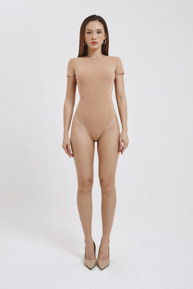 Beige / nude crew neck short sleeve bodysuit that is made from organic cotton for women