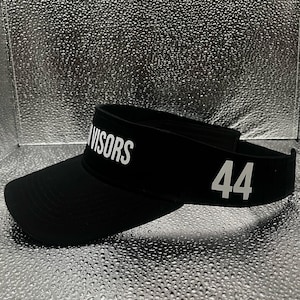 May include: A black visor featuring the white text VISORS printed on the front panel and the number 44 in white on the side. The headwear has a curved brim and an adjustable strap at the back, constructed from a solid black fabric material.