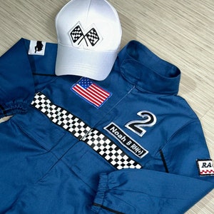 May include: Blue racing jumpsuit with a checkered belt, a white cap with checkered flags, an American flag patch, and the number 2 with the name "Noah B. RH#" on it.