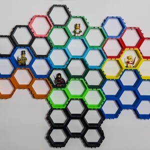 May include: A hexagonal shelf unit with 20 compartments in various colors, including black, red, orange, yellow, green, blue, and white. The shelves are designed to hold small items, such as figurines or other collectibles.