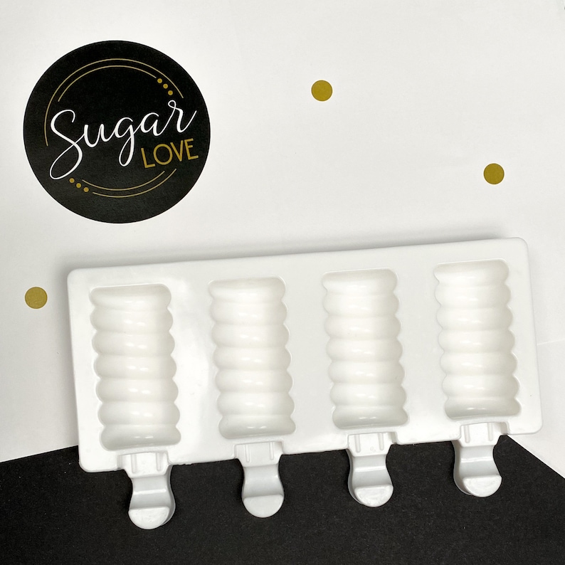 Peut inclure: Moule &agrave; popsicles en silicone blanc avec quatre moules individuels. Chaque moule a une texture c&ocirc;tel&eacute;e et une poign&eacute;e.