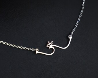 May include: A silver necklace with a delicate chain and a pendant featuring the Arabic letter "S" with a small diamond-shaped accent.
