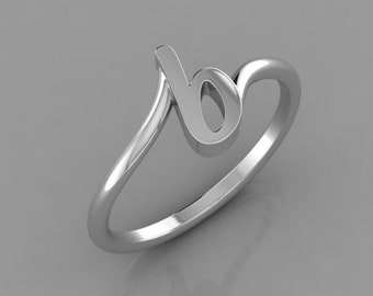 May include: A silver-colored ring featuring the cursive letter "b". The letter is integrated into the ring's design, with the band curving around to form a loop. The ring is set against a gray background.
