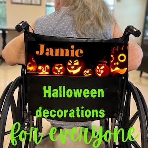 May include: A black rectangular sign attached to the back of a wheelchair featuring the orange text Jamie above a row of glowing orange jack-o'-lanterns. Below this, the text Halloween decorations for everyone is printed in bright green.