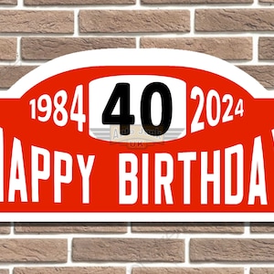 May include: Red and white sign with the text "1984 40 2024 Happy Birthday" on a brick wall background.