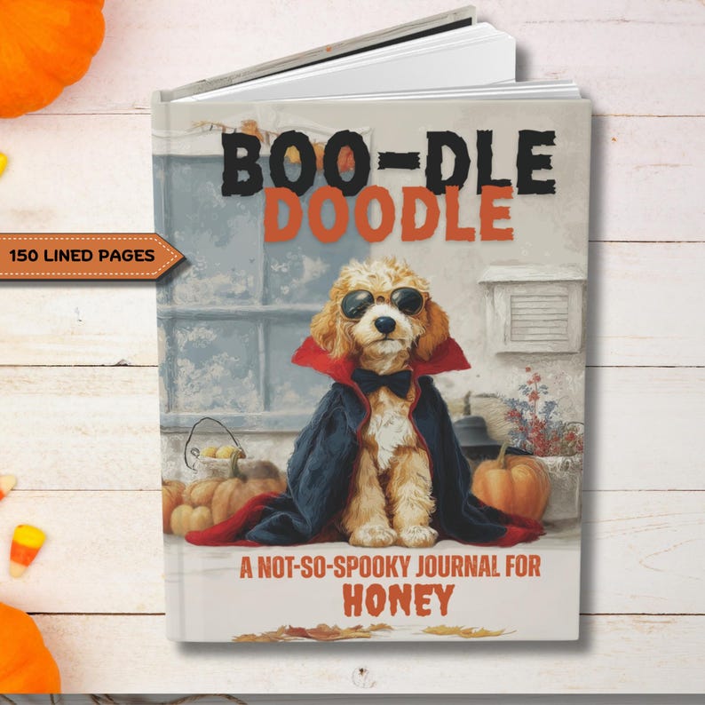 May include: A hardcover journal with the title "BOO-DLE DOODLE" and the text "A NOT-SO-SPOOKY JOURNAL FOR HONEY." The cover features a dog in a vampire costume, sunglasses, and a bow tie. The journal has 150 lined pages.