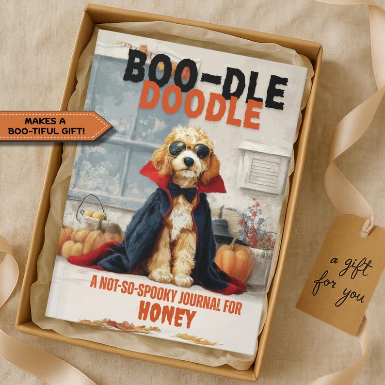 May include: A journal titled "BOO-DLE DOODLE" featuring a dog in sunglasses and a vampire cape. The journal is in a gift box with a tag that says "a gift for you". The journal is labeled "A NOT-SO-SPOOKY JOURNAL FOR HONEY".
