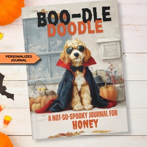 May include: A personalized journal with the words "BOO-DLE DOODLE" in black and orange. The cover features a dog in sunglasses and a vampire cape. The text "A NOT-SO-SPOOKY JOURNAL FOR HONEY" is also visible.