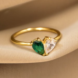 Peut inclure: Une bague en or avec une pierre précieuse en forme de poire verte et blanche.