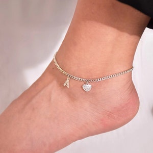 Puede incluir: Cadena de tobillo plateada con un dije de corazón y un dije de letra A.